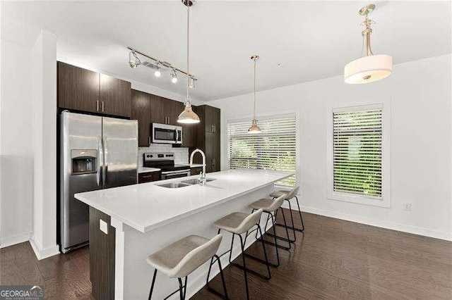 19 Moda Ln, Atlanta, GA 30316 - kitchen featuring stainless steel appliances, dark brown cabinetry, a breakfast bar area, dark wood-style flooring, and light countertops