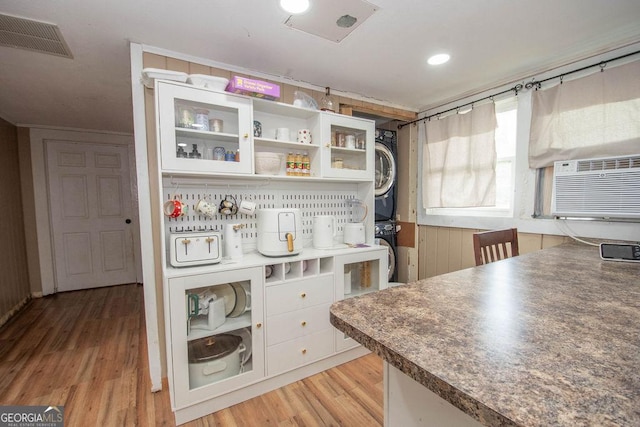 6110 Ga Highway 34, Franklin, GA 30217 - kitchen with stacked washer / dryer, light wood-style flooring, white cabinets, glass insert cabinets, and open shelves