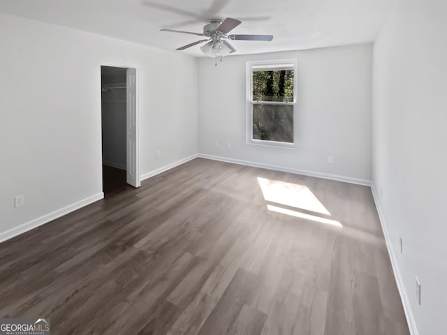 6220 Brookwood Rd, Peachtree Corners, GA 30092 - unfurnished bedroom featuring dark wood finished floors, a ceiling fan, a spacious closet, and a closet