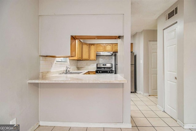 2039 Oak Park Ln, Decatur, GA 30032 - kitchen with stainless steel range, under cabinet range hood, freestanding refrigerator, light countertops, and decorative backsplash