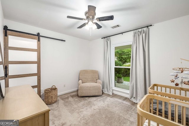 5315 Bentley Hall Dr, Alpharetta, GA 30005 - bedroom with a barn door, a crib, a ceiling fan, and wood finished floors