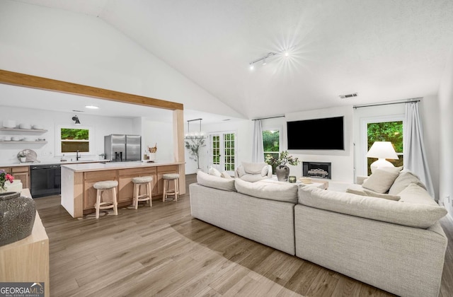 5315 Bentley Hall Dr, Alpharetta, GA 30005 - living area featuring vaulted ceiling, light wood-type flooring, a fireplace, a chandelier, and recessed lighting