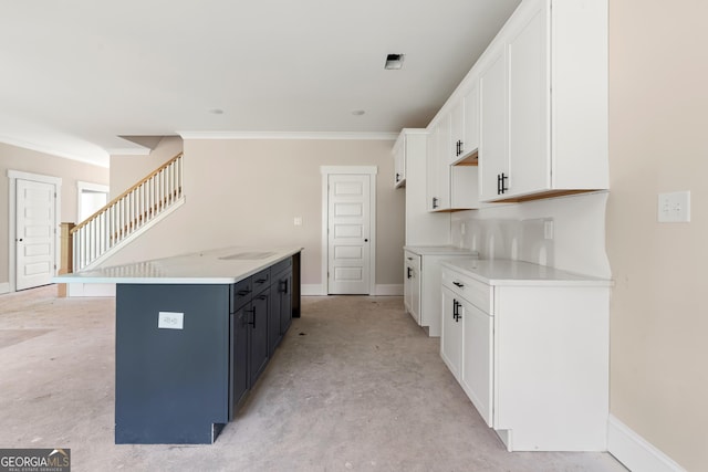 195 Grove Point Rd, Athens, GA 30605 - kitchen with ornamental molding, white cabinets, light countertops, and concrete floors