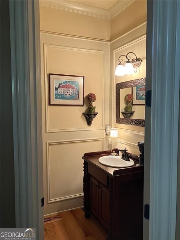 154 Gold Leaf Trl, Powder Springs, GA 30127 - half bathroom featuring vanity, crown molding, and wood finished floors