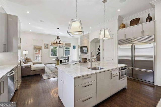 2883 Andrews Dr NW, Atlanta, GA 30305 - kitchen with stainless steel appliances, white cabinetry, open floor plan, dark wood finished floors, and decorative light fixtures