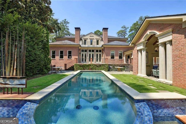 2883 Andrews Dr NW, Atlanta, GA 30305 - back of house featuring an outdoor pool, a chimney, a patio, a balcony, and brick siding