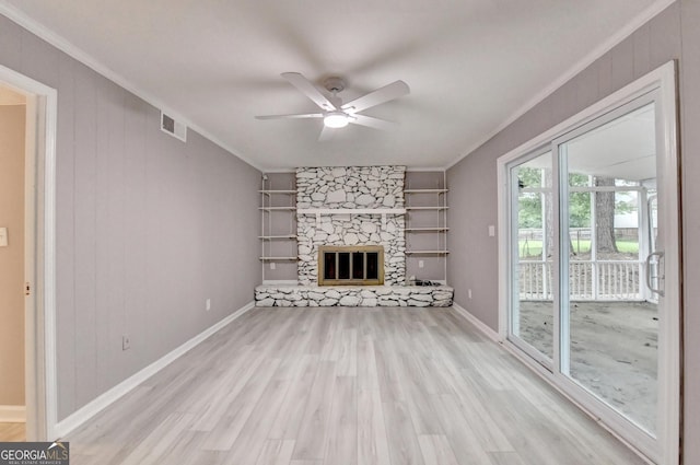 1094 SW Amber Rdg SW, Lilburn, GA 30047 - unfurnished living room with crown molding, light wood-style floors, ceiling fan, built in features, and a stone fireplace