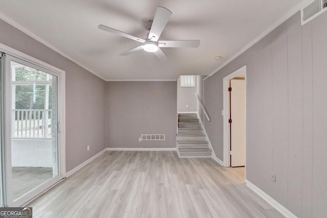 1094 SW Amber Rdg SW, Lilburn, GA 30047 - unfurnished living room with a ceiling fan, ornamental molding, light wood-type flooring, and stairway