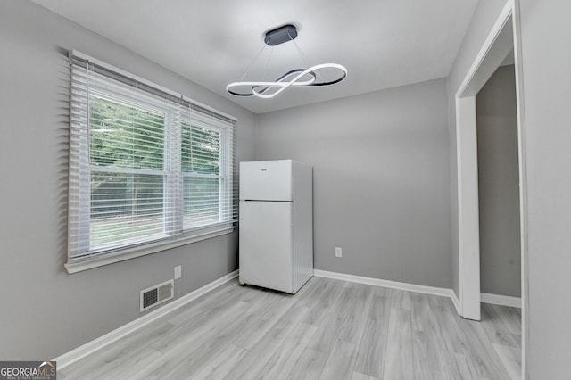 1094 SW Amber Rdg SW, Lilburn, GA 30047 - unfurnished dining area with light wood finished floors and a chandelier