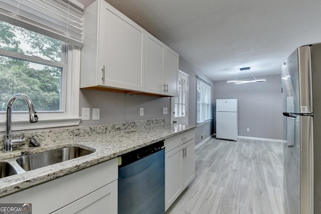 1094 SW Amber Rdg SW, Lilburn, GA 30047 - kitchen with dishwasher, freestanding refrigerator, white cabinetry, and light stone counters