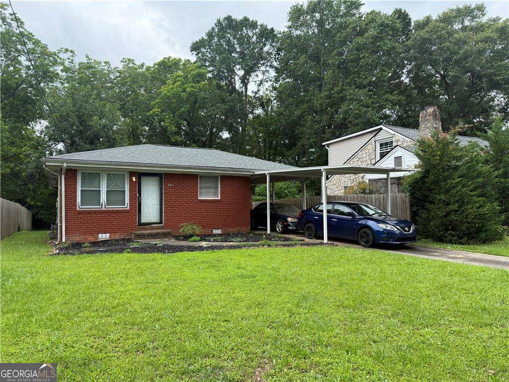2431 Crestview Ave, Decatur, GA 30032 - view of front of house featuring brick siding, a carport, crawl space, driveway, and roof with shingles