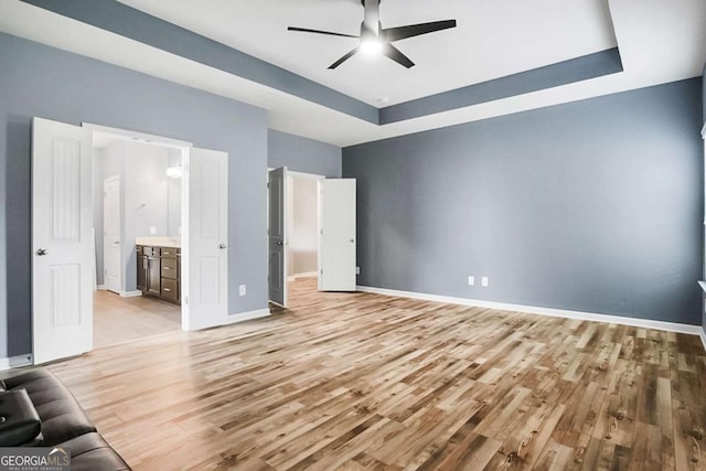 132 Berkleigh Trails Dr, Hiram, GA 30141 - unfurnished bedroom featuring light wood-style floors, a tray ceiling, ensuite bathroom, and a ceiling fan