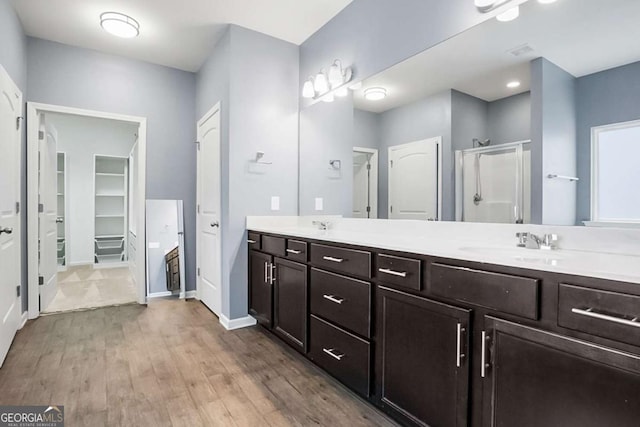 132 Berkleigh Trails Dr, Hiram, GA 30141 - full bathroom with a shower stall, a walk in closet, double vanity, and wood finished floors
