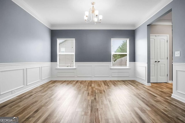 132 Berkleigh Trails Dr, Hiram, GA 30141 - empty room featuring a chandelier, a wainscoted wall, wood finished floors, ornamental molding, and a decorative wall