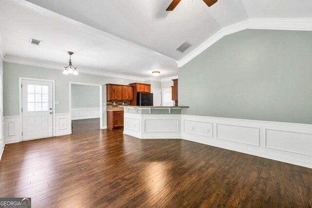 4371 Shag Bark Trl, Gainesville, GA 30507 - unfurnished living room with ceiling fan, a chandelier, wainscoting, dark wood finished floors, and ornamental molding