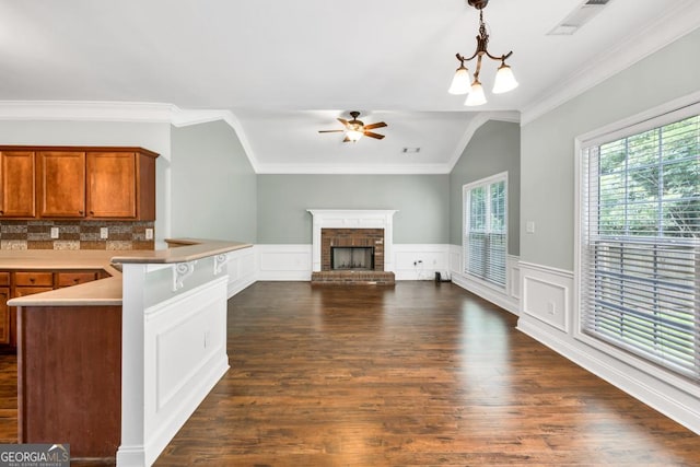 4371 Shag Bark Trl, Gainesville, GA 30507 - kitchen featuring a peninsula, brown cabinetry, ceiling fan, crown molding, and dark wood finished floors