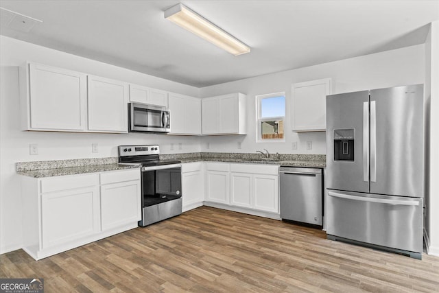 104 Middleton Ct, Chatsworth, GA 30705 - kitchen with stainless steel appliances, wood finished floors, white cabinets, and stone countertops