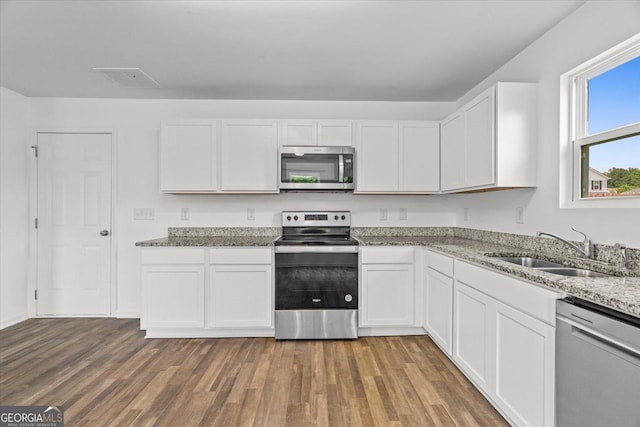 104 Middleton Ct, Chatsworth, GA 30705 - kitchen featuring stainless steel appliances, wood finished floors, white cabinetry, and light stone countertops