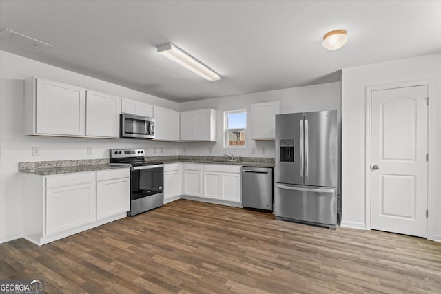 104 Middleton Ct, Chatsworth, GA 30705 - kitchen featuring stainless steel appliances, dark wood-style flooring, and white cabinetry