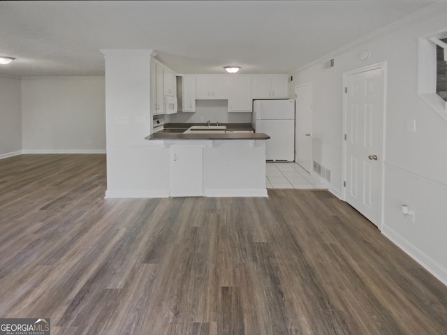 1480 D NE Pine Log Rd Unit D, Conyers, GA 30012 - kitchen with white appliances, dark countertops, a peninsula, white cabinets, and wood finished floors