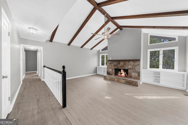 2945 Thompson Mill Rd, Gainesville, GA 30506 - unfurnished living room with beam ceiling, a fireplace, wood finished floors, ceiling fan, and high vaulted ceiling