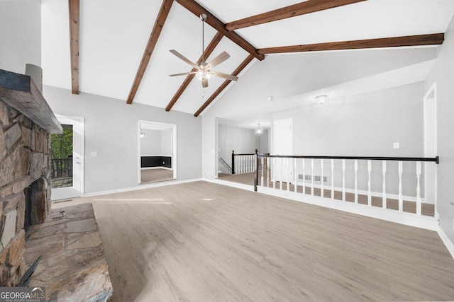 2945 Thompson Mill Rd, Gainesville, GA 30506 - unfurnished living room with wood finished floors, a fireplace, ceiling fan, beam ceiling, and high vaulted ceiling