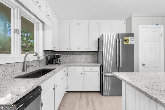 2945 Thompson Mill Rd, Gainesville, GA 30506 - kitchen with stainless steel appliances, light wood-type flooring, white cabinets, and light stone countertops
