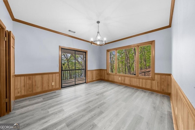 2945 Thompson Mill Rd, Gainesville, GA 30506 - spare room featuring wainscoting, a chandelier, light wood-style flooring, crown molding, and wood walls