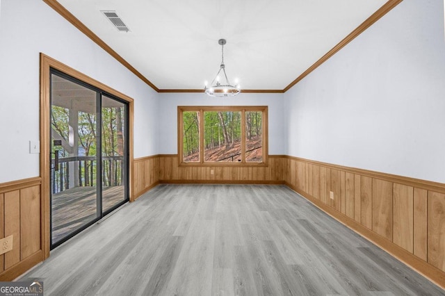 2945 Thompson Mill Rd, Gainesville, GA 30506 - unfurnished dining area with wainscoting, light wood-style flooring, a chandelier, wood walls, and crown molding