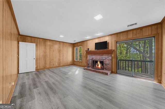 2945 Thompson Mill Rd, Gainesville, GA 30506 - unfurnished living room with crown molding, wooden walls, a fireplace, and wood finished floors