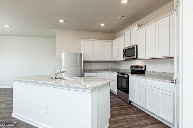 288 Oliver Dr, Locust Grove, GA 30248 - kitchen with appliances with stainless steel finishes, dark wood-style floors, recessed lighting, white cabinets, and an island with sink