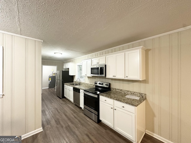 3403 Linda Dr, Lithia Springs, GA 30122 - kitchen with appliances with stainless steel finishes, a textured ceiling, dark wood-style floors, white cabinetry, and crown molding