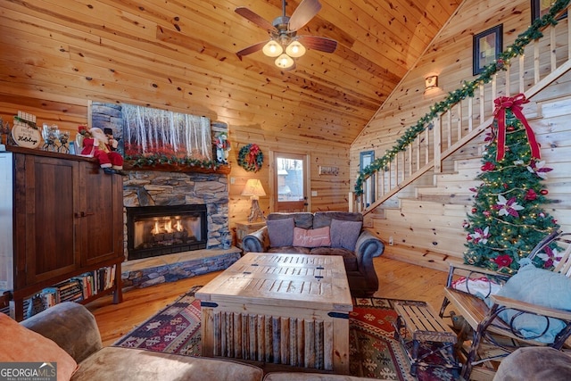 588 Tower Rd, Mineral Bluff, GA 30559 - living room with hardwood / wood-style flooring, ceiling fan, a stone fireplace, wooden ceiling, and wooden walls