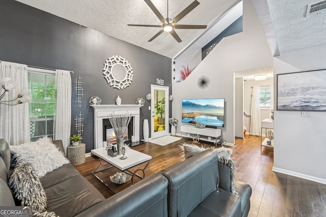 4467 Pineridge Cir, Atlanta, GA 30338 - living room with a textured ceiling, ceiling fan, hardwood / wood-style flooring, high vaulted ceiling, and a glass covered fireplace