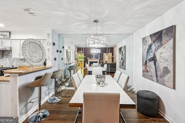 4467 Pineridge Cir, Atlanta, GA 30338 - dining area featuring dark wood-type flooring, a textured ceiling, and a chandelier