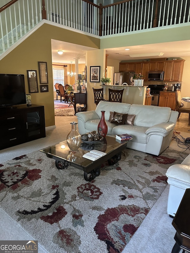 7946 Gossamer Dr, Fairburn, GA 30213 - living area with a towering ceiling, a chandelier, and stairs
