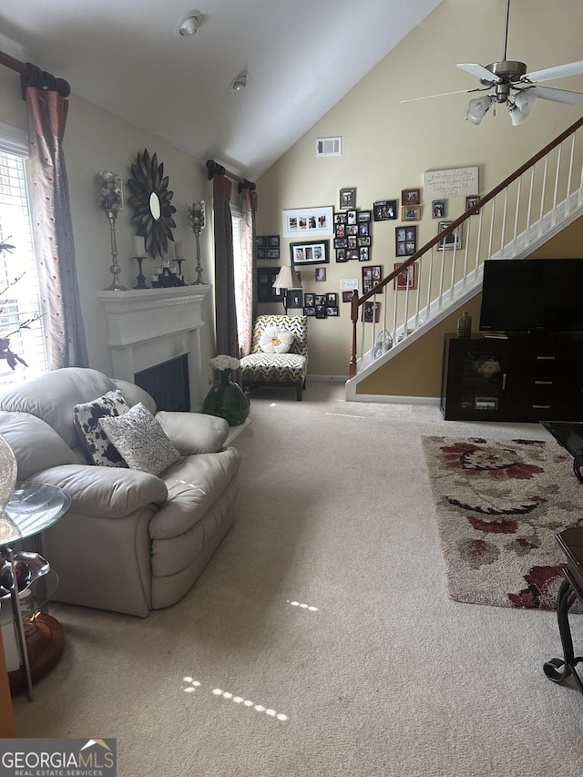 7946 Gossamer Dr, Fairburn, GA 30213 - living room with lofted ceiling, stairs, carpet, a fireplace, and ceiling fan