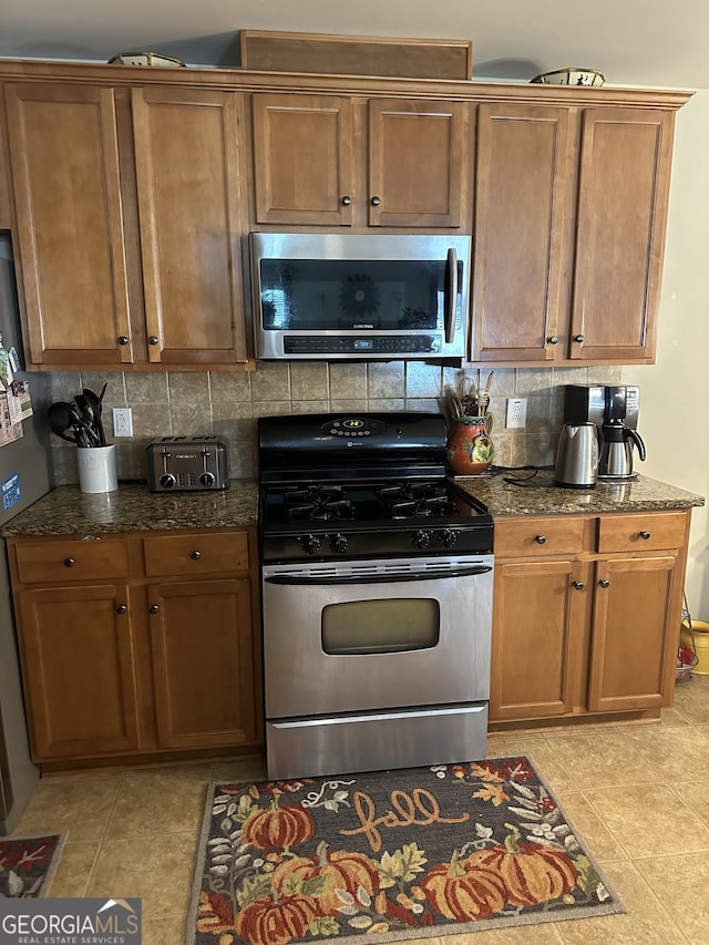 7946 Gossamer Dr, Fairburn, GA 30213 - kitchen with appliances with stainless steel finishes, decorative backsplash, and dark stone counters
