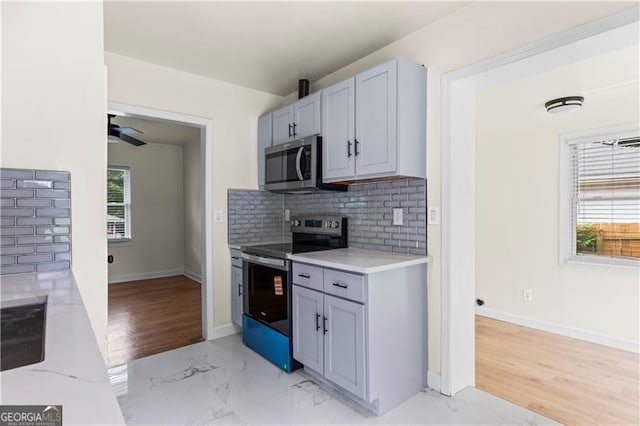 821 Springvalley Dr, Forest Park, GA 30297 - kitchen featuring stainless steel appliances, light countertops, backsplash, light marble finish flooring, and a ceiling fan