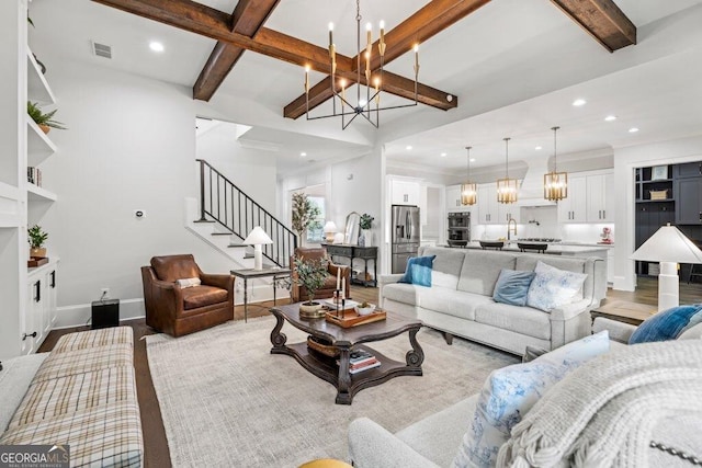 2381 Jones Phillips Rd, Dacula, GA 30019 - living room with a chandelier, beam ceiling, stairway, recessed lighting, and light wood-type flooring
