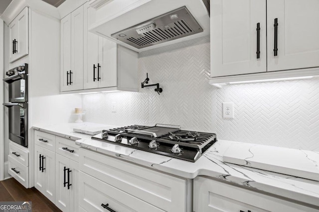 2381 Jones Phillips Rd, Dacula, GA 30019 - kitchen featuring premium range hood, black gas cooktop, white cabinetry, and backsplash