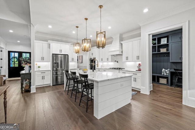 2381 Jones Phillips Rd, Dacula, GA 30019 - kitchen with stainless steel fridge with ice dispenser, wall chimney exhaust hood, a chandelier, ornamental molding, and a breakfast bar area