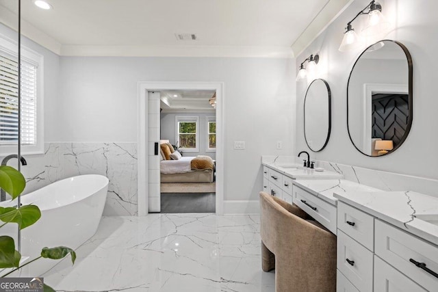 2381 Jones Phillips Rd, Dacula, GA 30019 - full bathroom with marble tiled floors, a freestanding bath, vanity, connected bathroom, and a wainscoted wall
