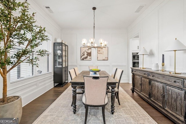 2381 Jones Phillips Rd, Dacula, GA 30019 - dining room with a decorative wall, a chandelier, dark wood-style flooring, and crown molding