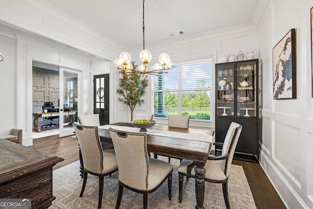 2381 Jones Phillips Rd, Dacula, GA 30019 - dining space featuring a decorative wall, a chandelier, wood finished floors, crown molding, and an office area