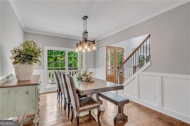 5301 Regency Lake Ct, Sugar Hill, GA 30518 - dining room featuring a decorative wall, ornamental molding, french doors, a chandelier, and wood finished floors