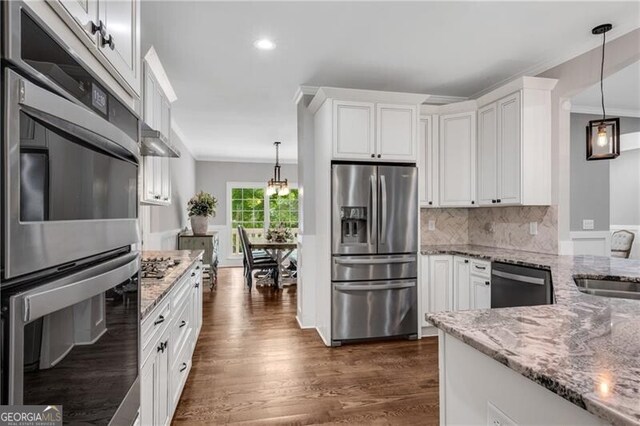 5301 Regency Lake Ct, Sugar Hill, GA 30518 - kitchen with stainless steel appliances, light stone counters, white cabinetry, decorative backsplash, and pendant lighting