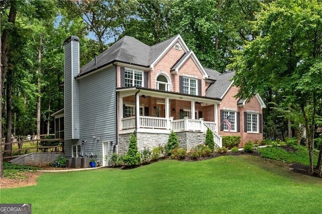 5301 Regency Lake Ct, Sugar Hill, GA 30518 - view of front of property with a chimney, a front lawn, covered porch, stairway, and brick siding