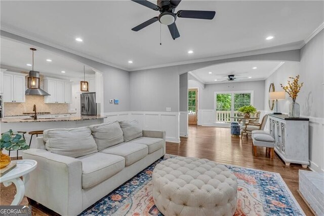 5301 Regency Lake Ct, Sugar Hill, GA 30518 - living area with ceiling fan, ornamental molding, arched walkways, dark wood-style flooring, and recessed lighting
