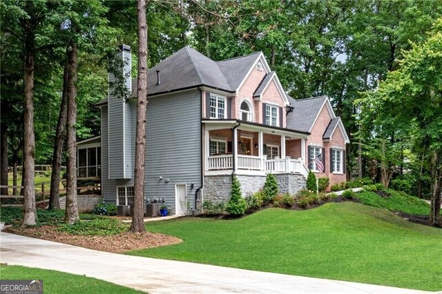 5301 Regency Lake Ct, Sugar Hill, GA 30518 - view of home's exterior with a chimney, a sunroom, and a patio